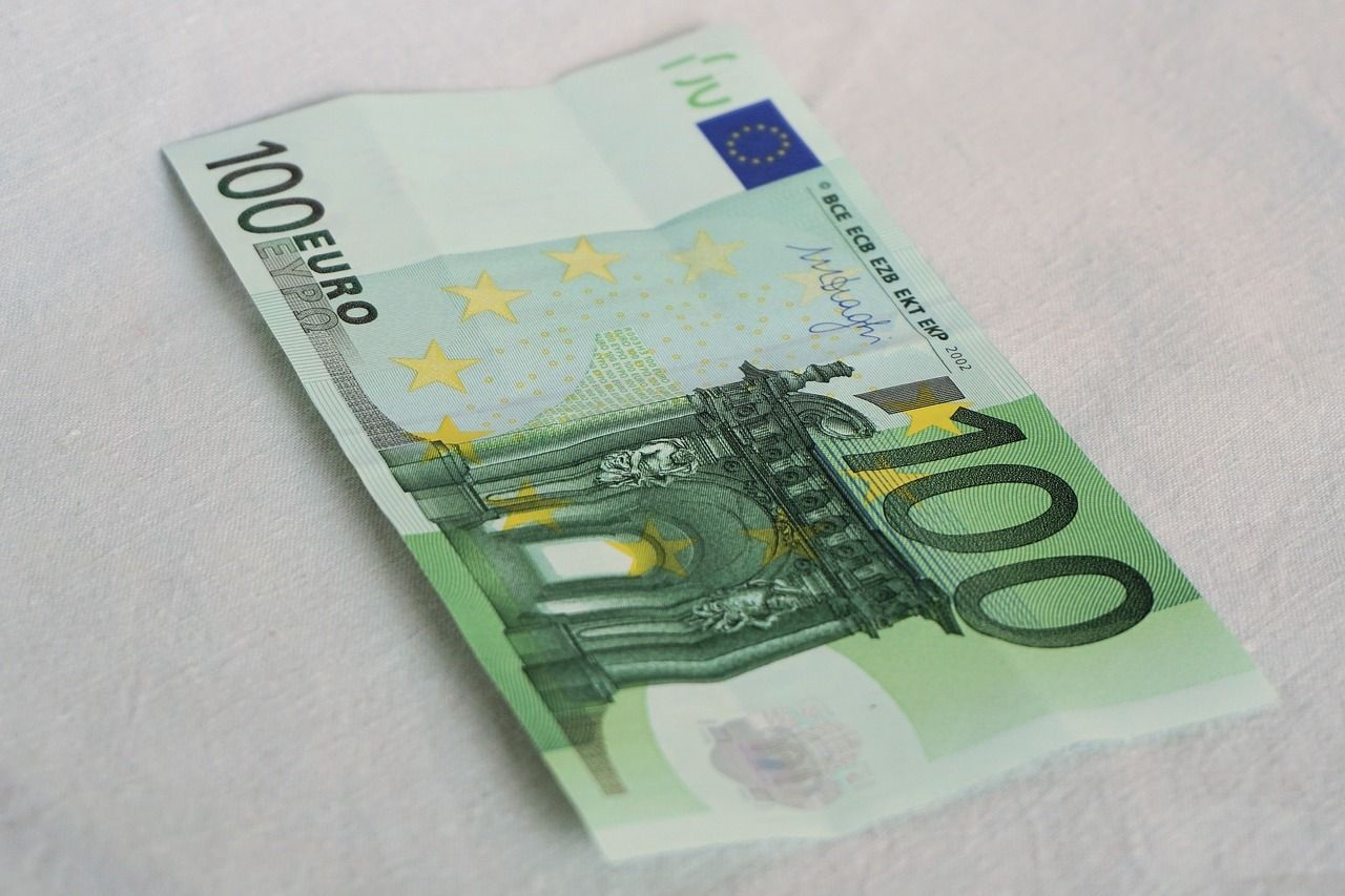 billet de 100€ posé sur une table qui représente la somme de l'aide "indemnité inflation"