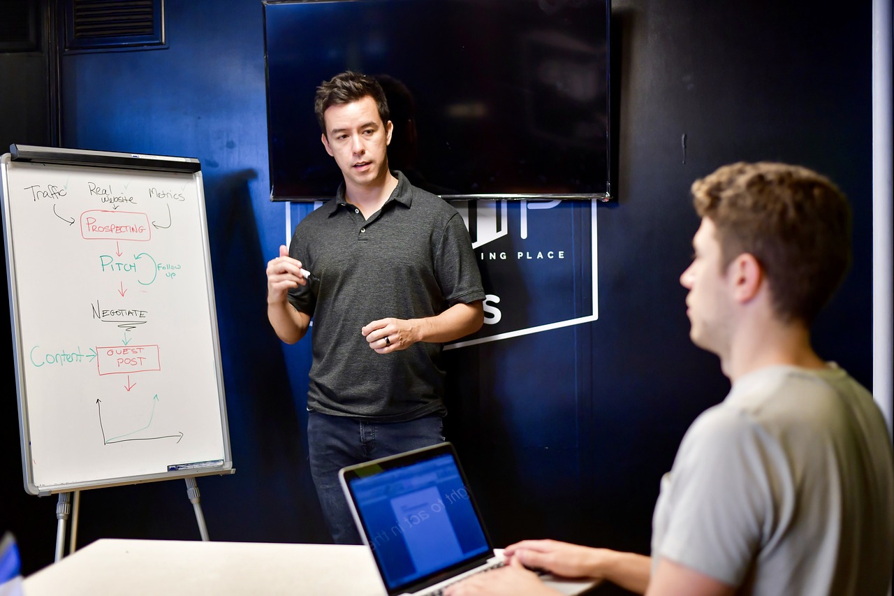 un formateur est en train de réaliser la formation de son apprentis en utilisant un tableau.